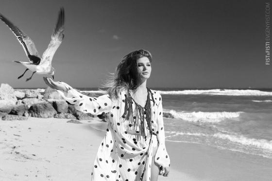 Черно-белое фото на пляже девушка на фоне волн с чайкой