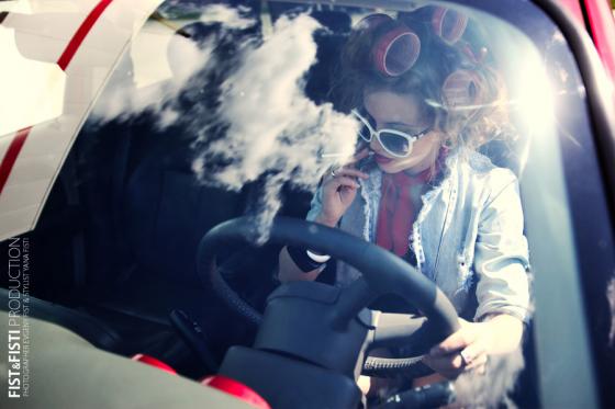 Фото девушка с бигуди курит сигарету за рулем авто