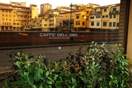 Отражение моста Понте-Веккьо в витрине Итальянсокго ресторана Caffe Delloro