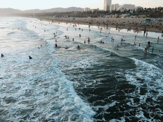 Люди купающиеся на пляже Санта-Моники в Лос-Анджелесе в Америке 
