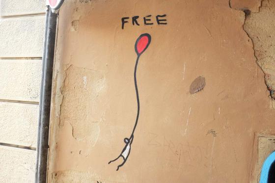 Стрит-арт на улицах города Флоренция человек держит красный шарик в руках